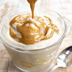 caramel sauce being drizzled over the top of a dessert in a glass bowl