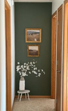 a room with green walls and pictures on the wall