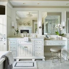 a large bathroom with white cabinets and marble floors