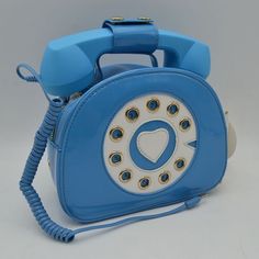 a blue and white purse with an old fashioned phone attached to it's side