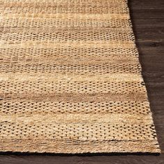 an area rug made out of jute on a wooden floor