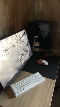 a computer monitor sitting on top of a wooden desk next to a keyboard and mouse