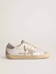 A timeless icon yet one that’s constantly evolving. At Golden, we love taking our classics and reworking them all the time, always from a new angle. These Super-Star sneakers with a white leather upper feature an ice-gray suede star and a silver glitter heel tab. The ice-gray suede insert and tongue and cream laces add the finishing touch. Golden Goose Women, Silver Glitter Heels, Golden Family, Gold Glitter Stars, Constantly Evolving, Glitter Heels, Lace Jewelry, Lace Socks, Pink Metallic