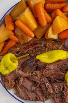 a white plate topped with roast, carrots and potatoes