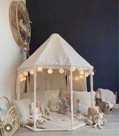 a white tent with teddy bears in it and lights on the ceiling, next to other stuffed animals