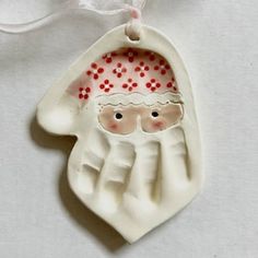 a ceramic ornament with a santa clause on it's face and hands