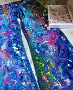 two pieces of art are laying on the floor next to each other, with paint splattered all over them