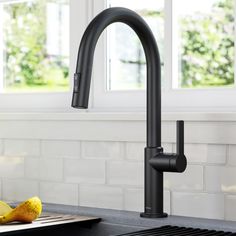 a black kitchen faucet sitting next to a cutting board