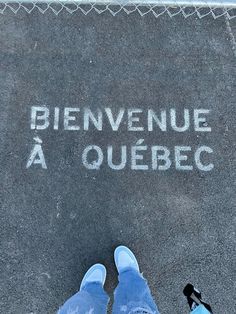 a person standing in front of a sidewalk that has writing on it and the words'bienvenue a quebec '