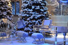 a room with christmas trees, piano and other decorations