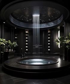 a large circular bathtub in a black room with lights on the ceiling and potted plants next to it