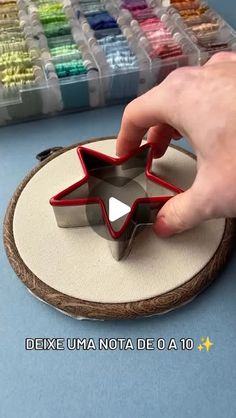 a person is making a star shaped object out of cookie tins on a table