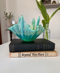 two books are stacked on top of each other, one has a blue flower in it