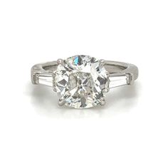 an oval cut diamond ring with baguets on the shoulders and side stones set in white gold