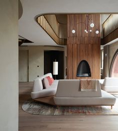 a living room filled with furniture and a fire place in the middle of it on top of a hard wood floor