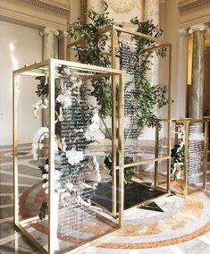 a glass display case with flowers and writing on the wall in a room filled with marble flooring