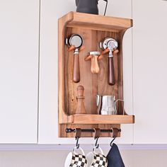 a wooden shelf with pots and pans hanging from it's hooks on the wall