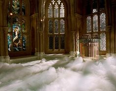 a large room with stained glass windows and snow on the floor