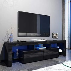 an entertainment center with a flat screen tv mounted on it's side, in front of a large window