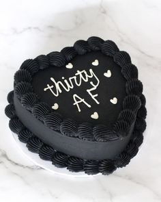 a black cake with white hearts and the words twenty four written on it in cursive writing