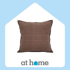 a brown pillow sitting on top of a blue and white sign that says at home