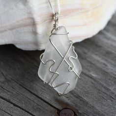 Found on the beaches in Cape May, this piece of sea glass was found by our artist and carefully wire-wrapped in sterling silver wire to make this stunning pendant. The pendant measures 1.85" in length from the top of the bail to the bottom of the glass and is approximately 1" wide. The pendant has been placed on a 16" sterling silver box chain but other lengths are available for an additional cost. Beach Glass Wire Wrapping, Beach Wire Wrapped Glass Jewelry, Green Sea Glass Wire Wrapped Jewelry, Silver Wire-wrapped Necklace With Recycled Glass, Silver Sea Glass Necklace With Wire Wrapped Detail, Silver Box, Wire Wrapped Necklace, Oyster Shell, Box Chain