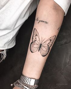 a woman's arm with a butterfly tattoo on the left side of her arm