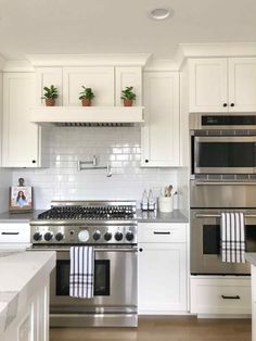 a kitchen with white cabinets and stainless steel appliances