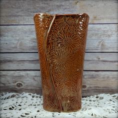 a brown vase sitting on top of a white doily