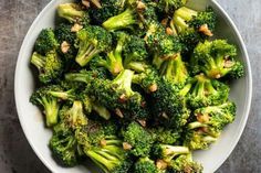 a white bowl filled with broccoli on top of a wooden table