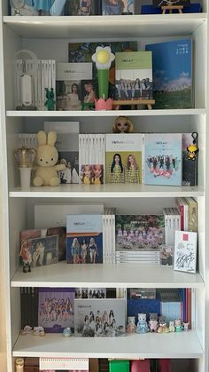 a white book shelf filled with books and other items on top of it's shelves