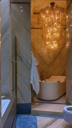 a bathroom with a chandelier hanging from the ceiling next to a bathtub