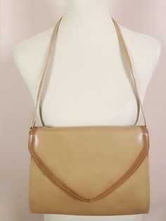 This classic 1970s shoulder bag is a timeless piece with its faux leather in a rich camel brown shade. The mid-brown trim and gold tone hardware add to its stylish air while the magnetic clasp flap closure ensures a secure closure. Inside, the cream fabric-lined interior splits into three compartments, one of which is zipped. Era - 1970s Brand - Van-Dal 21cm Width at top, 24cm Width at bottom x 18cm Height x 5cm Depth 33cm Shoulder strap drop Great condition, with a few light usage marks, interior pristine Vintage Brown Flap Shoulder Bag, Classic Beige Flap Bag For Formal Occasions, Brown Evening Flap Bag, Formal Beige Shoulder Bag With Magnetic Closure, Vintage Brown Flap Bag, Beige Flap Bag With Magnetic Closure, Formal Camel Shoulder Bag With Detachable Strap, Beige Formal Flap Bag, Vintage Evening Flap Bag