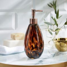 a brown glass soap dispenser sitting on top of a white marble counter