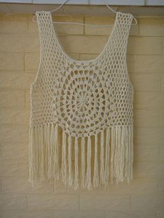 a crocheted top with fringes hanging on a wall