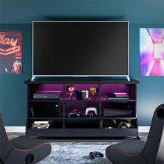 a flat screen tv sitting on top of a black entertainment center in a living room