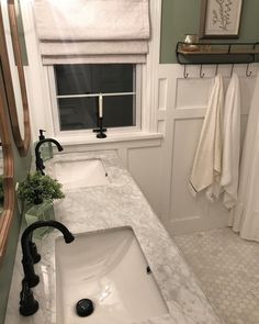 a white sink sitting under a window in a bathroom