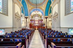 the inside of a church with rows of pews and stained glass windows on both sides