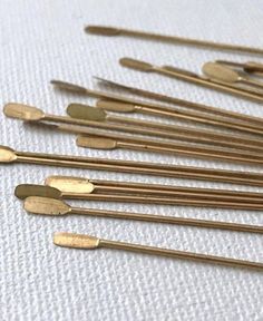 several gold colored spoons are lined up on a white surface