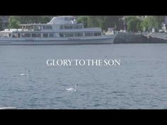 a large boat floating on top of a lake next to a white swan in front of the words glory to the son