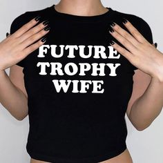 Future Trophy Wife Baby Tee, Women's Fitted Tee, Y2K Shirt, Trendy Top, Funny Shirt, Funny Sayings, 90s Style Tee DETAILS - 100% cotton (fiber content may vary for different colors) - tear-away label  SIZING Please find the size chart in the listing photo before purchasing. PLEASE NOTE: Our Baby tee is sized for a youth, reminiscent of the '90s-era shrunken-down T-shirt. This style, popularized by the skater/raver culture of the time, is not to be confused with the modern crop top. The baby tee 90s Funny Print Tops For Streetwear, Hip Hop Short Sleeve Tops With Funny Print, Hip Hop Tops With Funny Print And Short Sleeves, 90s Slogan Tops For Streetwear, Y2k Slogan Shirt For Streetwear, 90s Style Short Sleeve Tops With Funny Text, Retro Black Tops With Funny Text, Retro Black Top With Funny Text, 90s Crew Neck Shirt With Letter Print