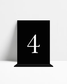 a black and white square with the number four in it's center on a table