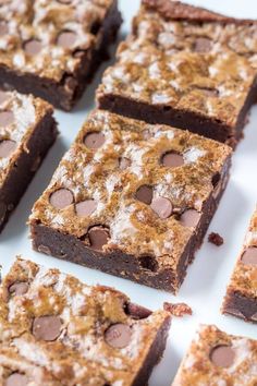 chocolate chip brownies are arranged on a white platter and ready to be eaten