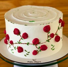 there is a white cake with red roses on it