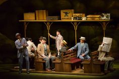 a group of men sitting on top of wooden benches