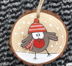 a wooden ornament with a bird wearing a red hat and scarf on it