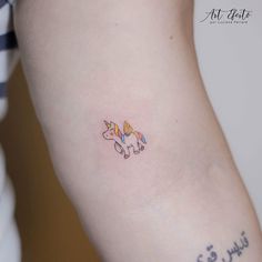 a small tattoo on the arm of a woman's left arm, with an image of a unicorn