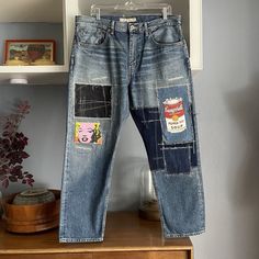 a pair of jeans with patches on them are hanging from a clothes rack in a room