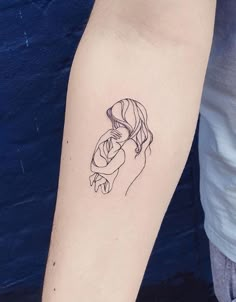 a woman's arm with a black and white drawing of a kissing couple on it