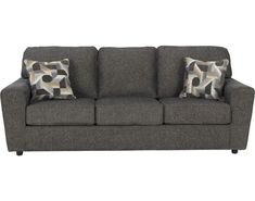 a gray couch with two pillows on it's back and one pillow in the middle